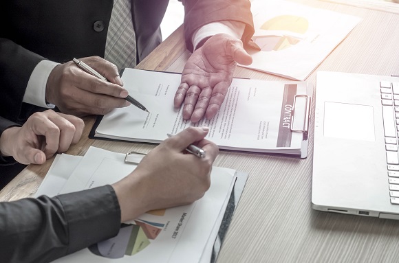 Two business men looking over contracts