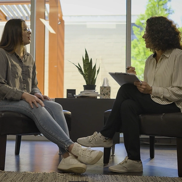 a counselor sees a patient in a sunlit office