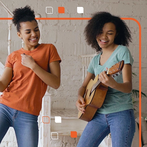 two teens dance while one plays guitar