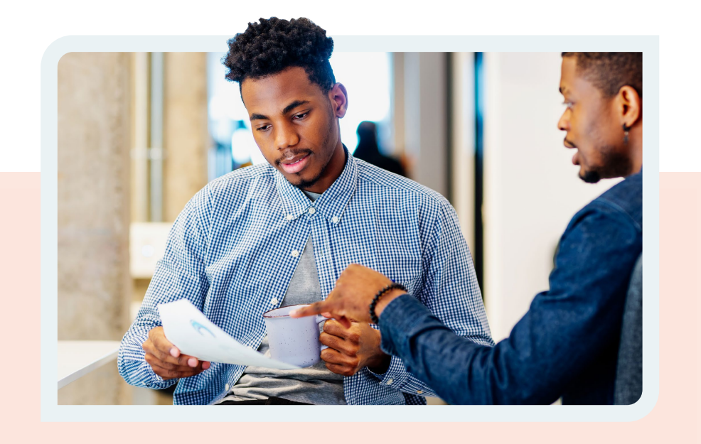 two african american men work together in an office