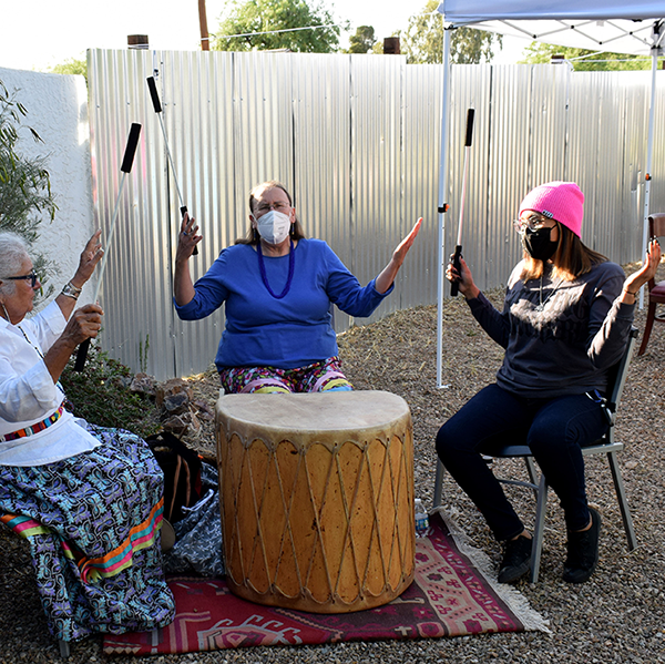 three women sit in a recovery drum circle