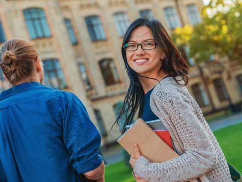 a female student walking outside on a campus