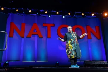 education speaker on stage at NatCon24