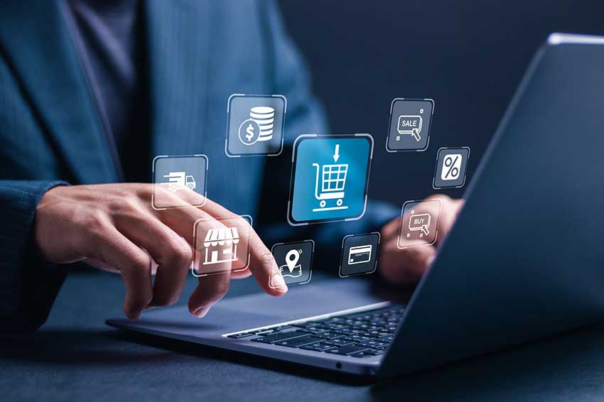 a man typing at a computer with icons floating up from it