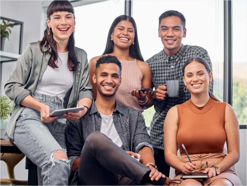 a group of young people smiling at the camera in an office
