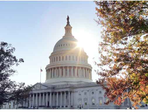 the capitol building with the sun behind it