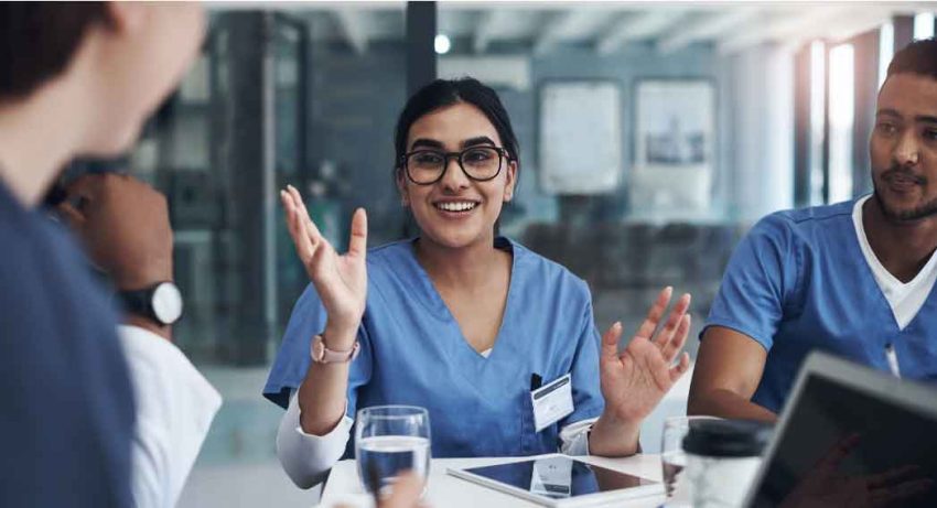 a woman explains something at table with other employees