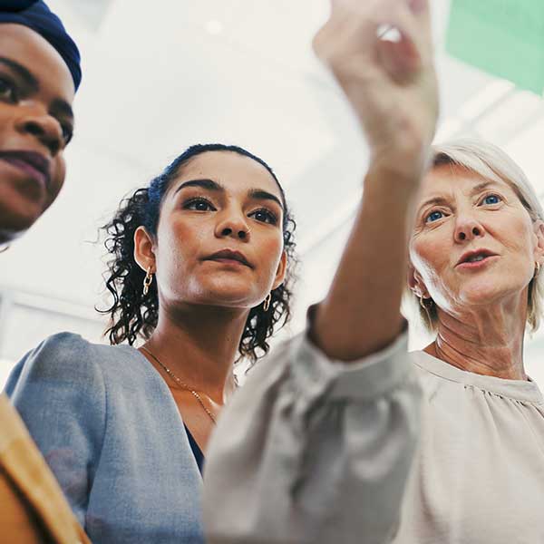 a woman points to something off camera while her coworkers look on