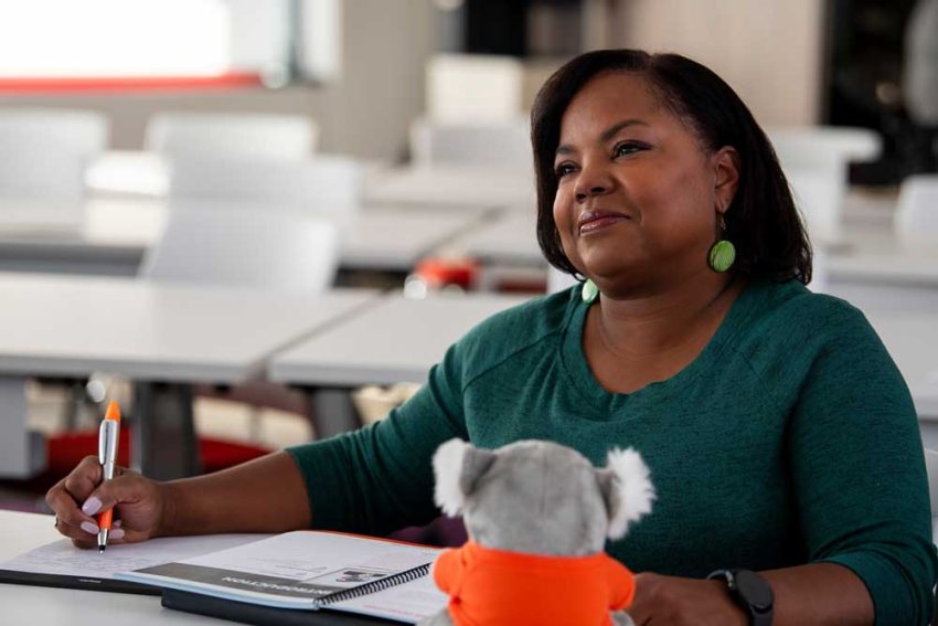 a woman sits at a table in a learning environment