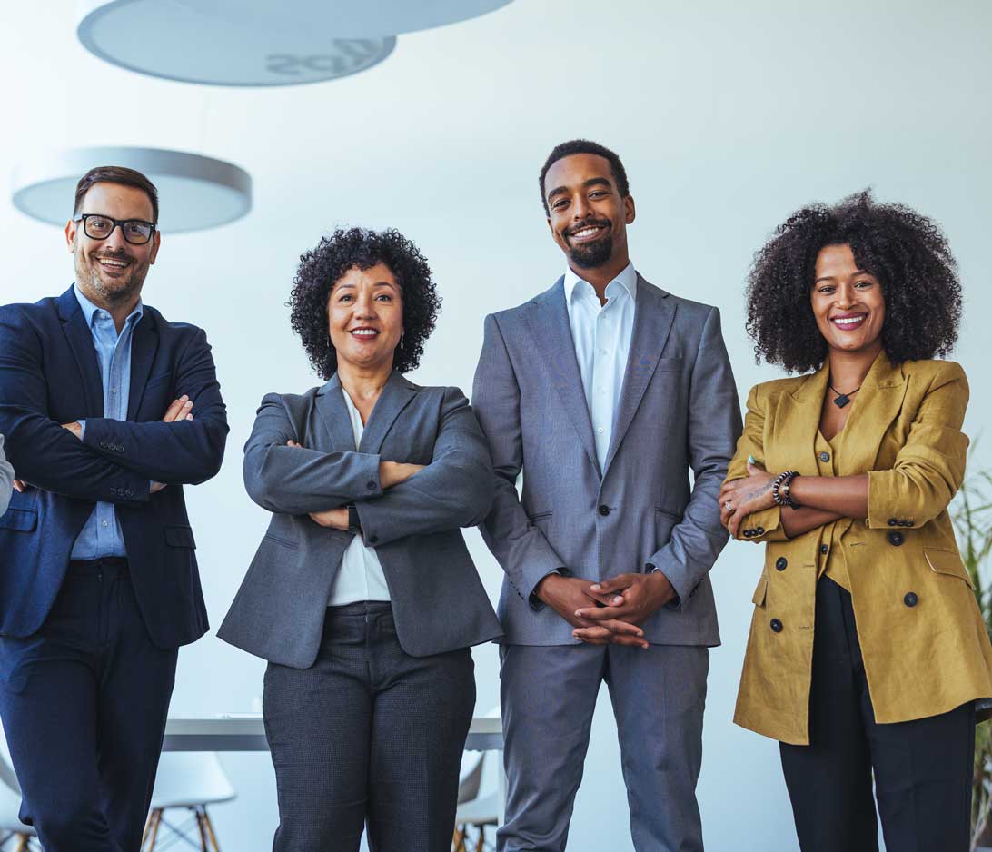 a group of young professionals with arms crossed smiling and facing the camera