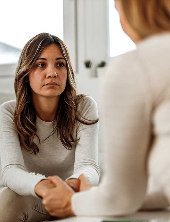 A woman listens to someone else looking concerned