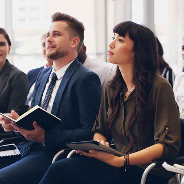 two people in a work seminar look on