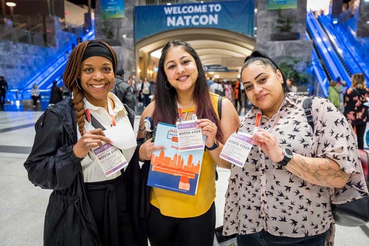 three women holding up their badges at natcon