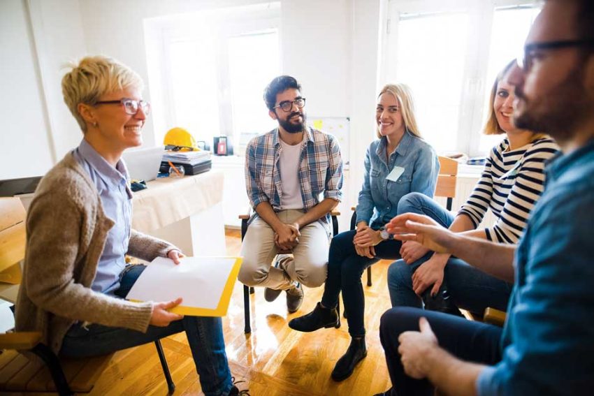 a group of people talk in a circle as if in a workshop