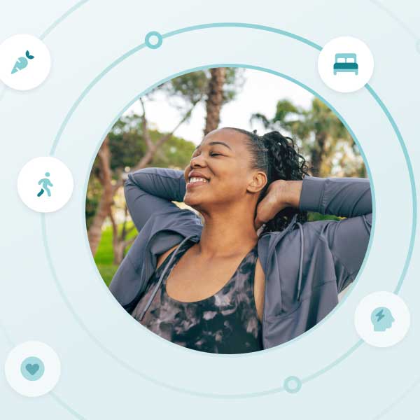 woman with her hands behind her head smiling and looking releaxed