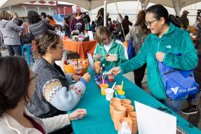 people hand out items at an event table